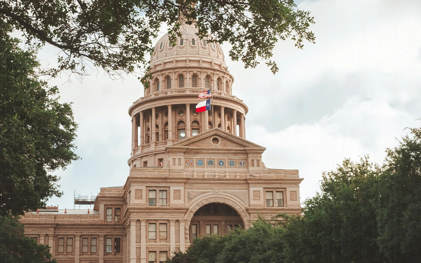The Texas Capitol dome framed by trees.